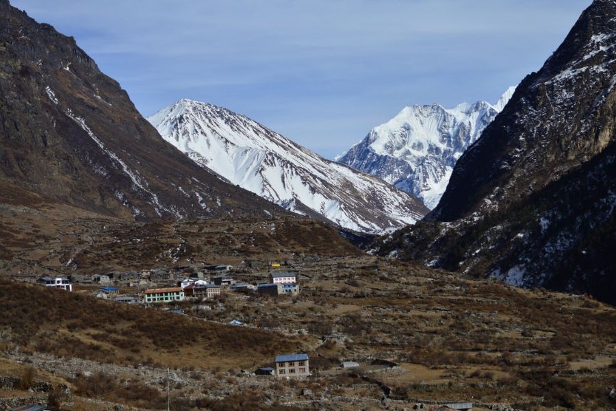 Remote Langtang settlement with scattered buildings below towering Himalayan peaks